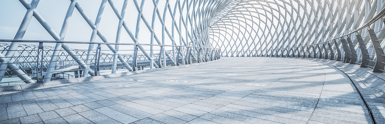 Futuristic pedestrian footbridge against sky