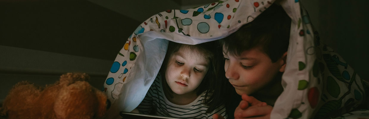 Two kids using a gadget.