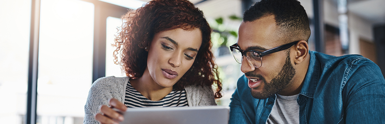 Shot of a young couple using a digital tablet while planning their budget together at home